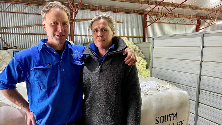 Farmers stand near wool bale