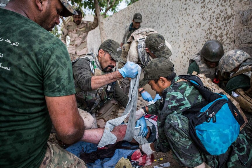 Bandaging a shot civilian's leg