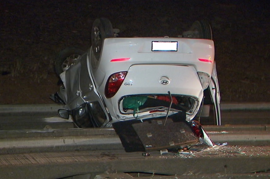 A hatchback upside down on a concrete path