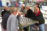 Residents of Fairfield in Sydney's west sit at a public table and talk