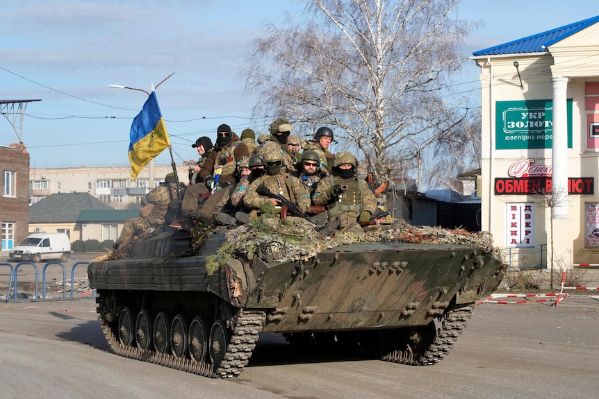 A group of Ukrainian soldiers ride on an armoured personnel carrier. 
