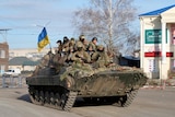 A group of Ukrainian soldiers ride on an armoured personnel carrier. 
