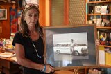 Ros Lowe holds a black and white photo of her murdered son Zane McCready standing in-front of a vintage car