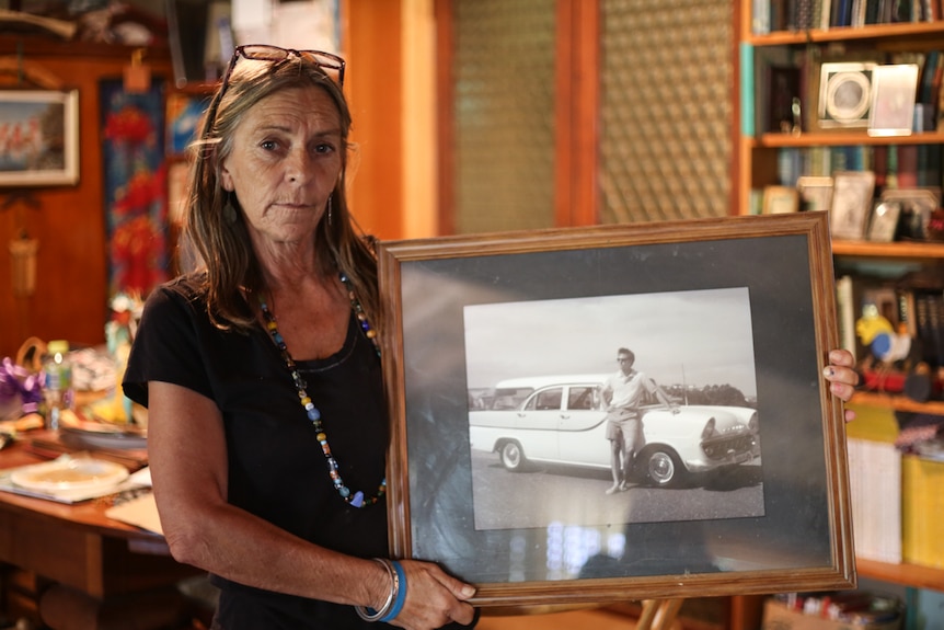 Ros Lowe holds a black and white photo of her murdered son Zane McCready standing in-front of a vintage car