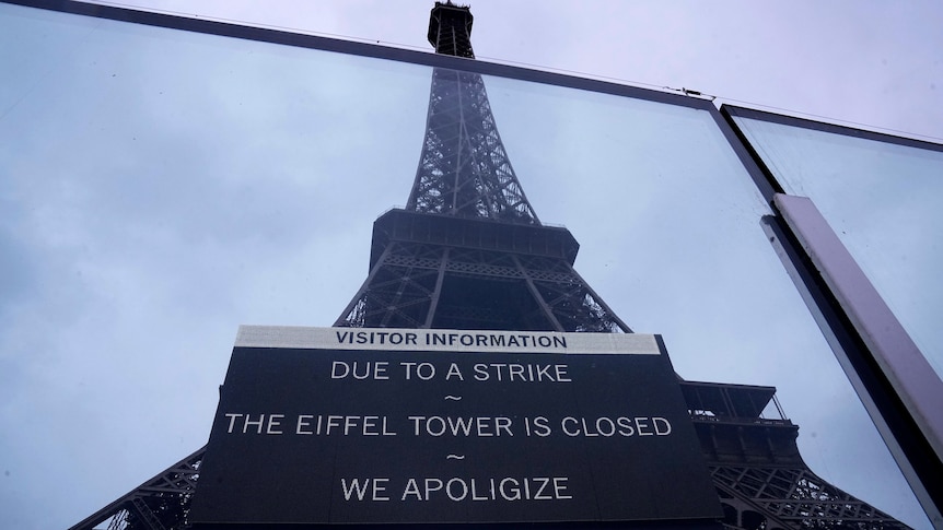 A sign in front of the Eiffel Tower that says due to strike eiffel tower is closed