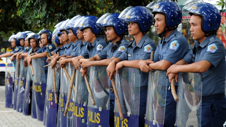 Riot police stand guard for possible protests along a major road near the APEC summit.