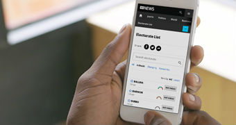 A mobile phone user looking at the ABC's NSW election night results page