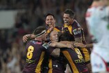 Match-winner: Lockyer is mobbed by his team-mates after his clinching the game for the Broncos.