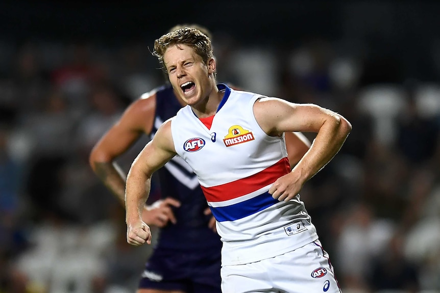 A Western Bulldogs AFL player screams out as he celebrates kicking a goal against Fremantle.