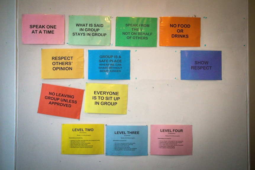 Colourful signs with statements like 'Speak one at time' and 'Respect others' opinion' on a whiteboard.