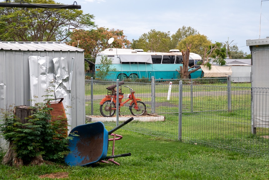 A old motorbike and bus visible from a backyard in Dingo, Queensland, November 2021.