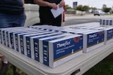 table with boxes of rapid antigen testing kits lined up