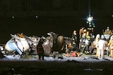Firefighters are seen near the part of the burnt Japanese Coast Guard aircraft on the runway of Haneda airport