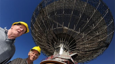 David Cooke (right) with former dish driver Neil Mason (left) underneath the Parkes radio telescope