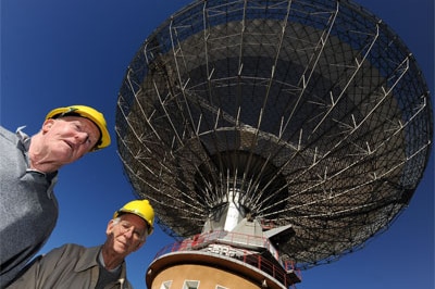 David Cooke (right) with former dish driver Neil Mason (left) underneath the Parkes radio telescope