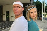 ABC reporters Tom Forbes and Ashleigh Stevenson standing back to back outside the ABC Brisbane building.