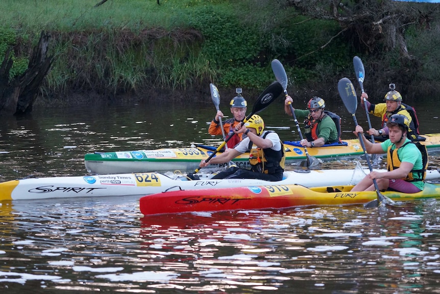 A group of kayakers close together on the Avon River during the Avon Descent.