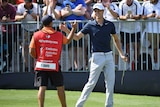 Cameron Davis of Australia celebrates with caddie after birdieing the last at the Australian Open.