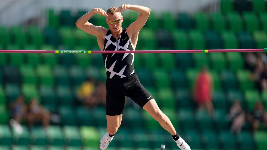 A US male pole vaulter clears the bar during a competition.