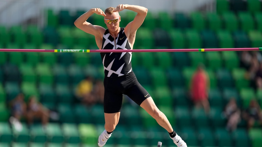 A US male pole vaulter clears the bar during a competition.