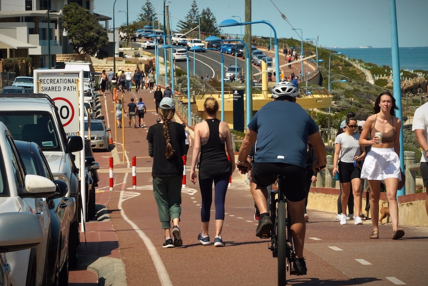 People cycle, walk and jog along a coastal path