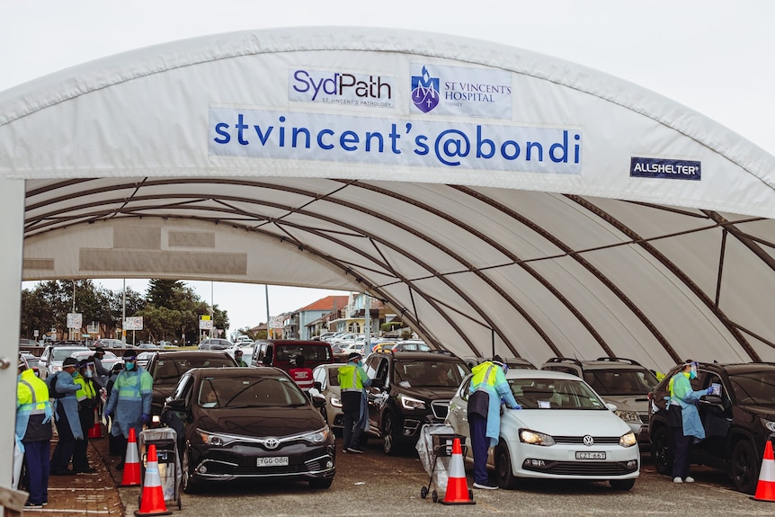 people under a tent talking to people in cars