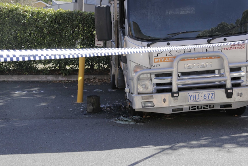 A truck with a broken window and damaged tyre.