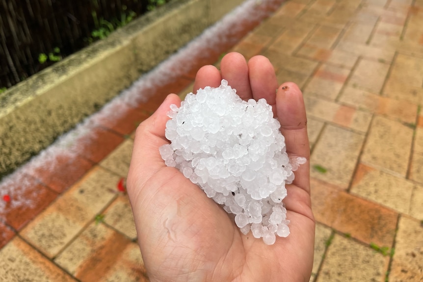 A close-up shot of a ball of hail stones in someone's hand.