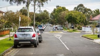 Cars parked on side of a suburban street