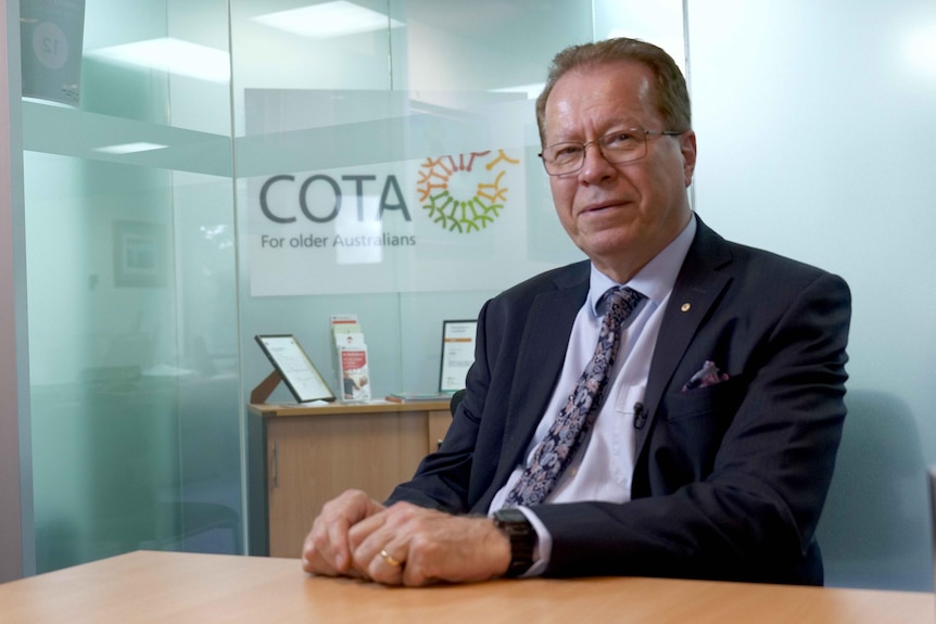 Ian Yates wearing a suit and sitting in an office.