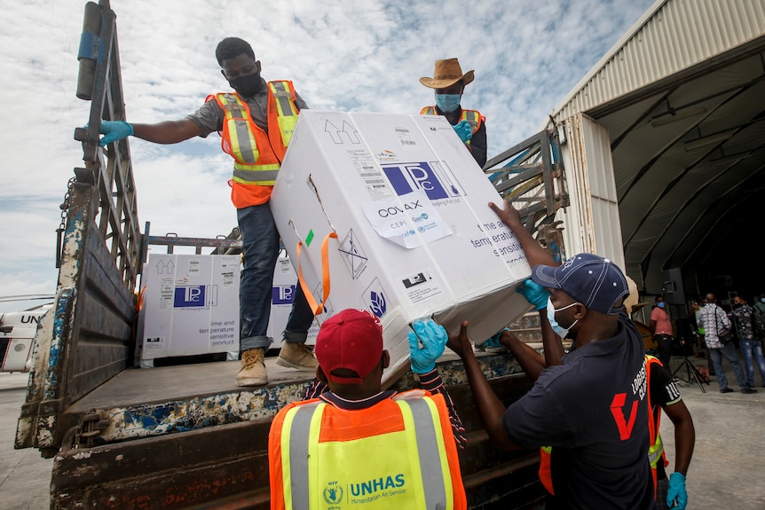 Boxes of COVID-19 vaccineare unloaded from the back of a truck by workers at the airport in Mogadishu.