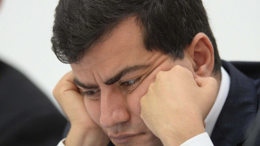 Sam Dastyari with his head in his hands.