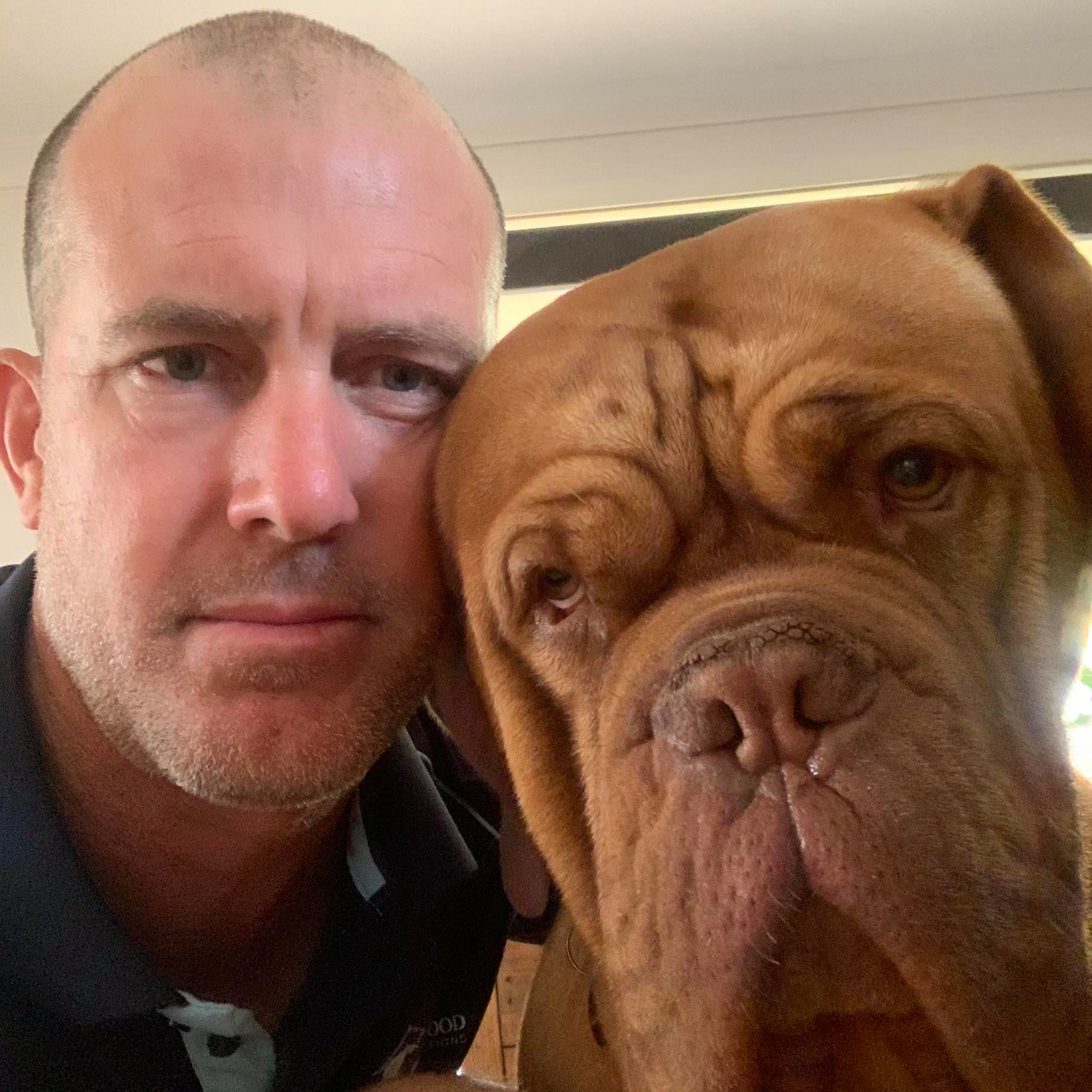 A selfie of Tony Begg next to his large brown dog. 