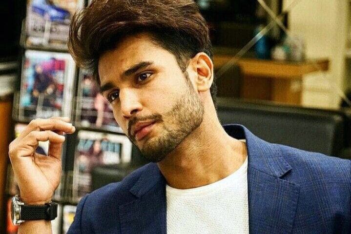 Well-dressed man in a cafe looks away from the camera.