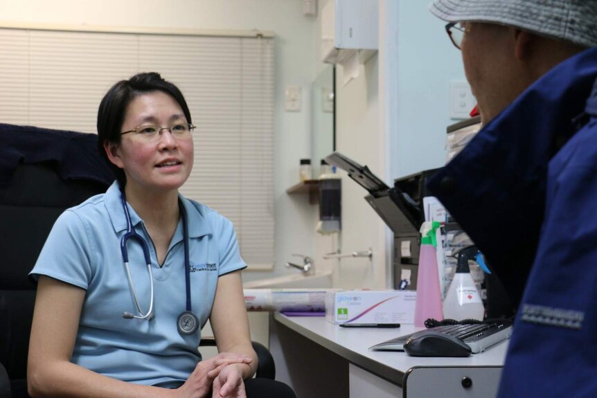 Dr Hui Cheng Tay with a patient in a doctors office.