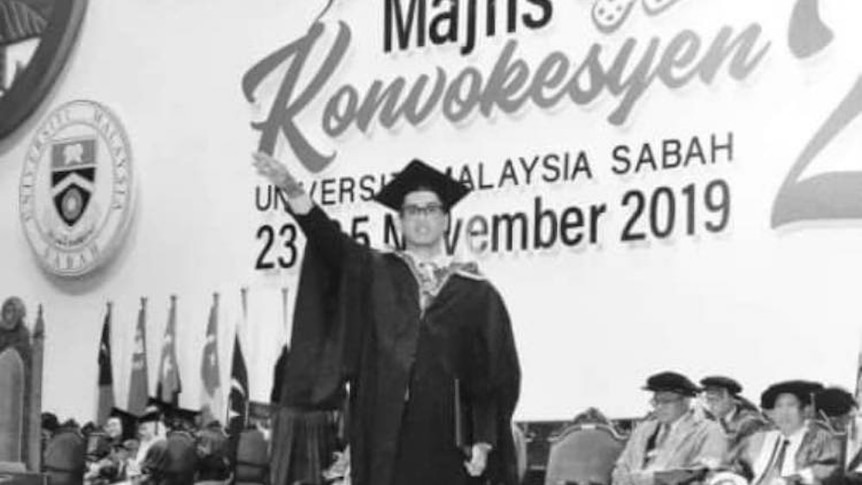 A black and white photo shows a man giving a Nazi salute on a stage.