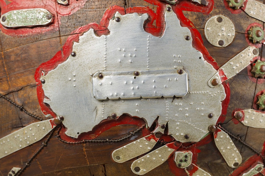 A close-up Braille map of Australia on a wood and aluminium globe.