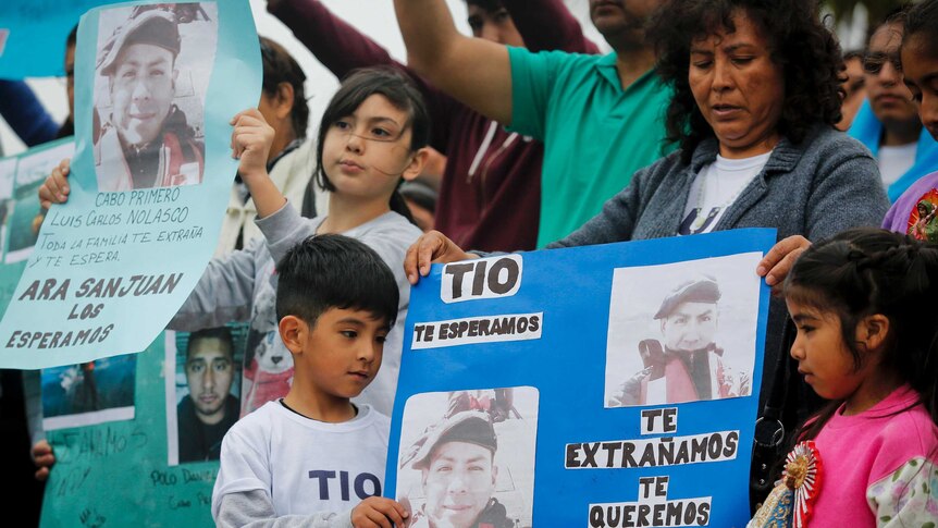 Relatives of Luis Carlos Nolasco protest with a sign outside the navy base in Mar del Plata.