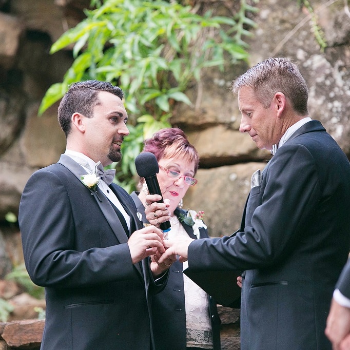 Two men exchanging rings in a civil ceremony.