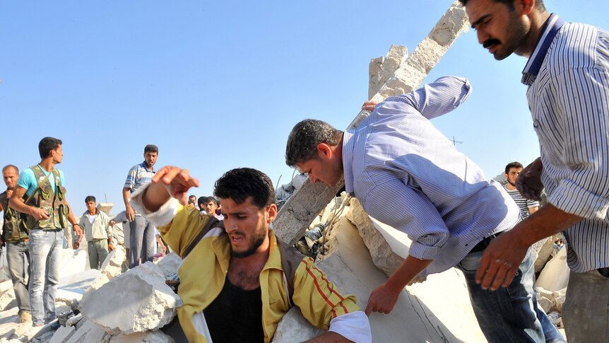 A man emerges from rubble in Syria