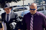 Michael Glenn Lewis wears sunglasses on the right, as he walks in with his lawyer.