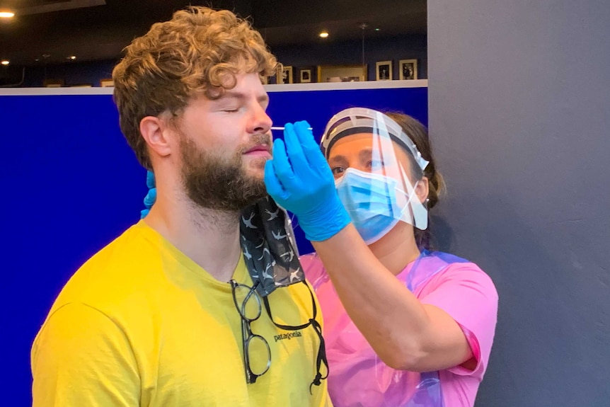 A young man getting a COVID-19 swab up the nose