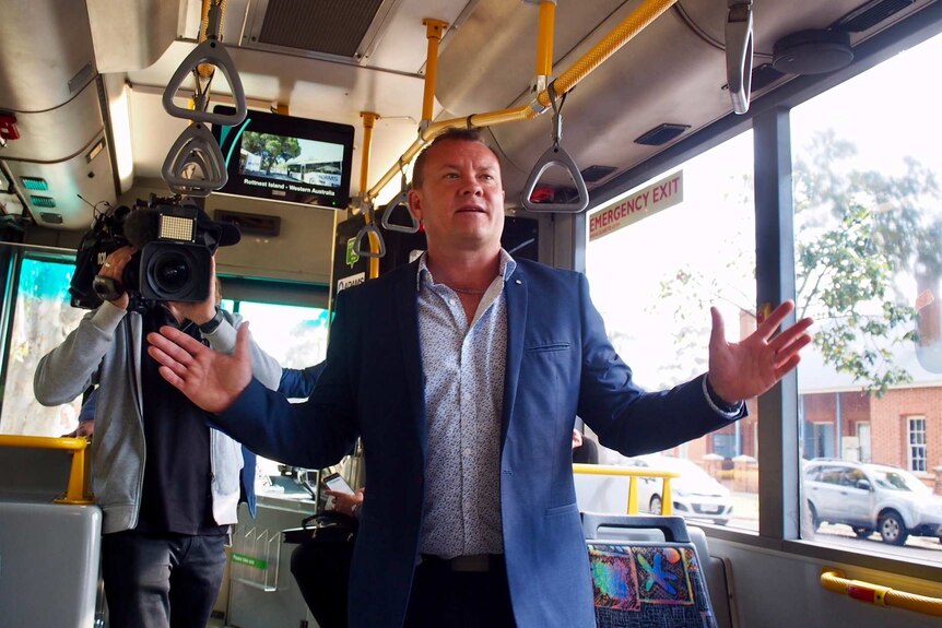 Adam Barnard standing inside the new bus.