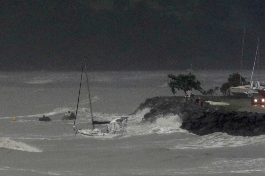 Waves generated by Cyclone Ita pound a yacht moments before it is dashed against rocks at Airlie Beach.