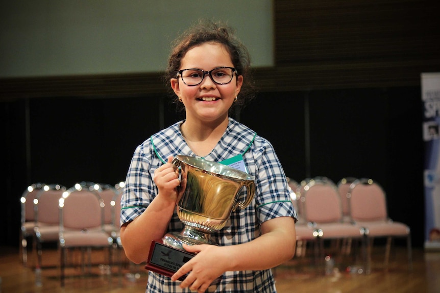 Nine-year-old Emilia McCarthy from Glenmore Park Public School smiling with her trophy.