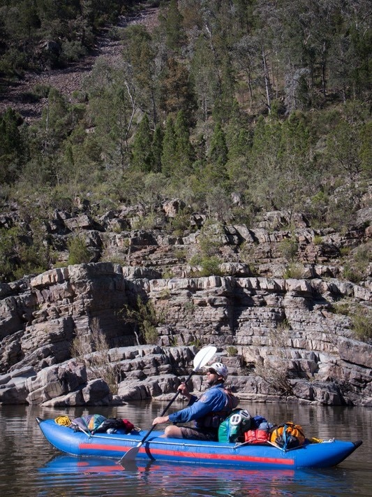 Tour guide canoeing in inflatable canoe in the Snowy River