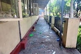 A long balcony is covered with shattered glass blown out from an explosion.