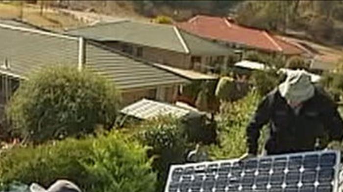 Two men installing solar panels on a house in Sydney