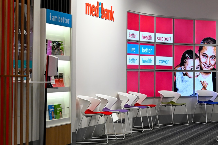 A ‘medibank’ logo is seen inside a shopfront with chairs set up like a waiting room