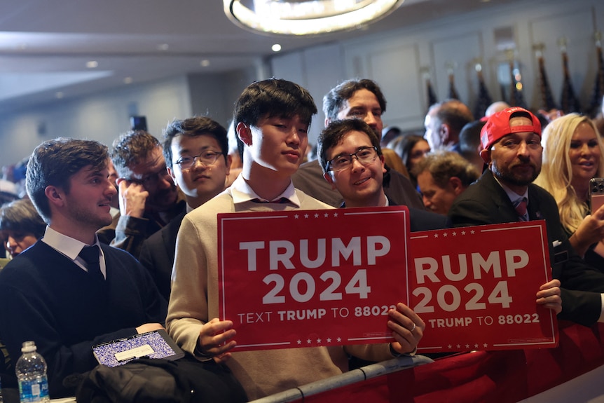 Men holding 'Trump 2024' signs 